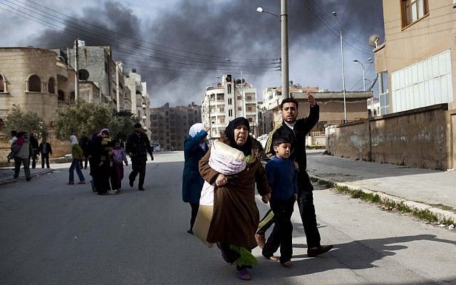 A family escapes from fierce fighting between Free Syrian Army fighters and government troops in Idlib, north Syria (photo credit: AP/Rodrigo Abd) A family escapes from fierce fighting between Free Syrian Army fighters and government troops in Idlib, north Syria (photo credit: AP/Rodrigo Abd)