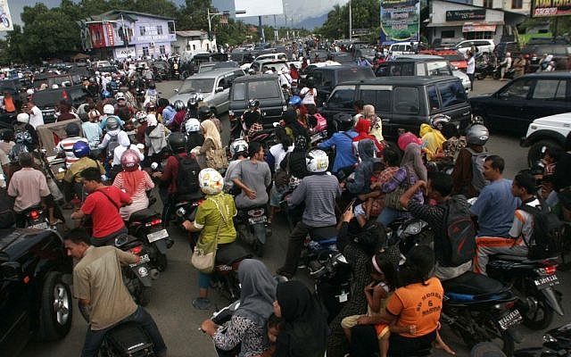 Indonesians stuck in a traffic jam as they flee to higher ground to escape a possible tsunami. (photo credit: AP/Heri Juanda)