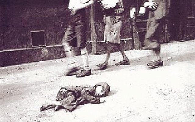 A child dying in the streets of the Warsaw Ghetto (photo credit: photo by Heinz Joest, a Wehrmacht sergeant, Wikimedia Commons)