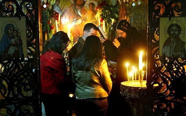 A Coptic priest blesses pilgrims in the Church of the Holy Sepulchre, Jerusalem (photo credit: Olivier Fitoussi/Flash90) A Coptic priest blesses pilgrims in the Church of the Holy Sepulchre, Jerusalem (photo credit: Olivier Fitoussi/Flash90)