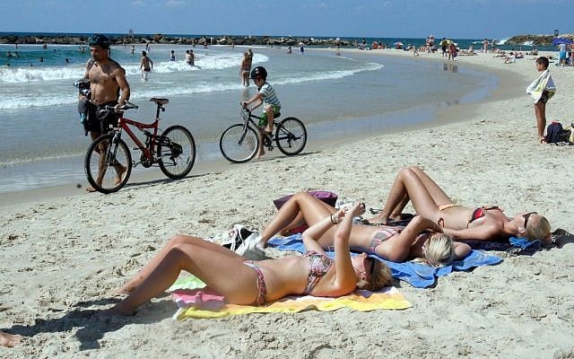Illustrative photo of women sunbathing on the beach in Tel Aviv. (Roni Schutzer/Flash90)