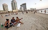Young Israelis on a Tel Aviv beach (Illustrative photo credit: Miriam Alster/Flash90)