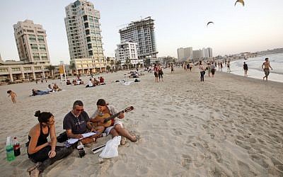 Young Israelis on a Tel Aviv beach (Illustrative photo credit: Miriam Alster/Flash90)