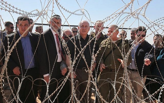 Prime Minister Benjamin Netanyahu (center) and Interior Minister Eli Yishai (2nd left) visit the Israeli-Egyptian border (photo credit: Amit Shabi/Flash90) Prime Minister Benjamin Netanyahu (center) and Interior Minister Eli Yishai (2nd left) visit the Israeli-Egyptian border (photo credit: Amit Shabi/Flash90)