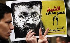 A Palestinian man holds up a poster of Palestinian prisoner Khader Adnan in protest of Adnan's previous administrative detention, February 10, 2012. (Sliman Khader/Flash90)