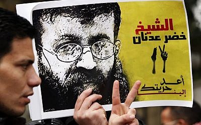 A Palestinian man holds up a poster of Palestinian prisoner Khader Adnan in protest of Adnan's previous administrative detention, February 10, 2012. (Sliman Khader/Flash90)
