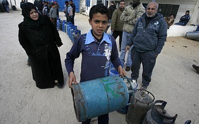 Palestinians wait to fill gas canisters at a fuel station in Khan Younis (photo credit: Abed Rahim Khatib/Flash 90)