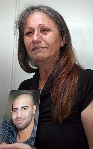 Amsis's mother with his picture in court on Tuesday. (photo credit: Gideon Markowicz/Flash90)