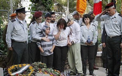 Friends and relatives of Hila Betzaleli surround IDF Chief of Staff Benny Gantz as he salutes after laying a flag on her grave at the Mount Herzl military cemetery on Sunday (photo credit: Miriam Alster/Flash90)