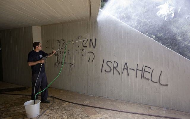 A worker cleans graffiti sprayed at Ammunition Hill on Monday (photo credit: Yossi Zamir/Flash 90) A worker cleans graffiti sprayed at Ammunition Hill on Monday (photo credit: Yossi Zamir/Flash 90)