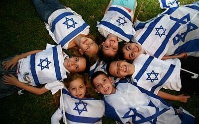 Children wave Israeli flags on Independence Day. (photo credit: Yehoshua Yosef /Flash90)