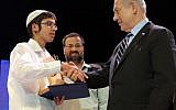 Elhanan Bloch, winner of the annual Bible Quiz, receives his first place prize from Prime Minister Benjamin Netanyahu at the Jerusalem Theater on Thursday. (photo credit: Avi Ohayon/GPO/Flash90)