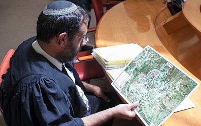 A lawyer looks over a map of Beit El prior to a High Court hearing in 2012 (Noam Moskowitz/Flash90)