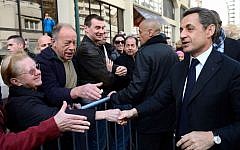French president and conservative candidate for the 2012 presidential election, Nicolas Sarkozy shakes hands with people as he arrives for a campaign meeting in April (photo credit: AP/Eric Feferberg)