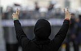 A Bahraini anti-government demonstrator gestures toward riot police during March protests in Manama (photo credit: AP/Hasan Jamali)