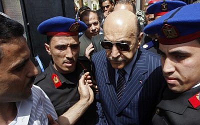 Former Egyptian Vice President Omar Suleiman is escorted by police after he submitted his candidacy papers at the Higher Presidential Elections Commission, in Cairo, April 7, 2012. (photo credit: AP Photo)