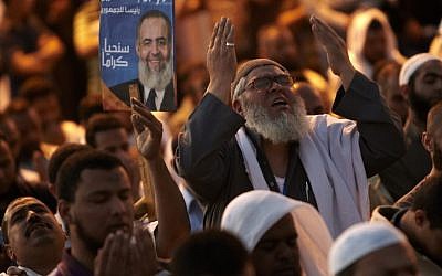 The day after tens of thousands of demonstrators packed Cairo's downtown Tahrir Square in the biggest demonstration in months against the ruling military, followers of Egyptian Muslim cleric and former presidential candidate Hazem Abu Ismail perform their evening prayer as they continue the protest. (photo credit: Fredrik Persson/AP)