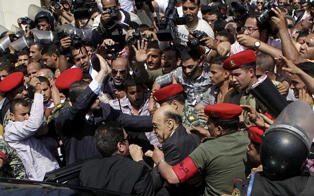 Former Egyptian Vice President Omar Suleiman, center, is escorted by military police as he prepares to submit his candidacy papers at the Higher Presidential Elections Commission on Sunday. (photo credit: AP/Amr Nabil) Former Egyptian Vice President Omar Suleiman, center, is escorted by military police as he prepares to submit his candidacy papers at the Higher Presidential Elections Commission on Sunday. (photo credit: AP/Amr Nabil)