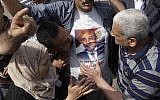 Supporters of Omar Suleiman kiss a T-shirt with his image (photo credit: AP/Amr Nabil)