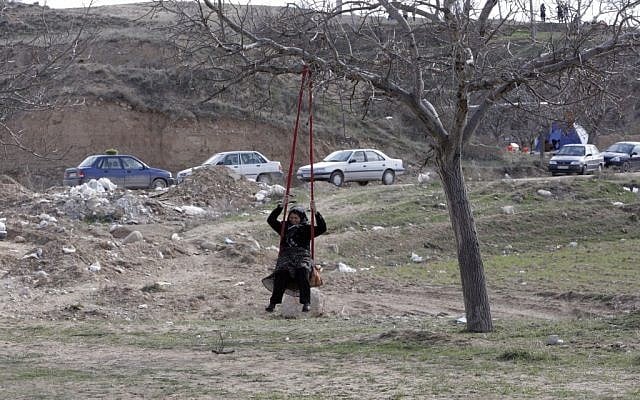 An Iranian woman plays on a swing during a picnic marking the ancient festival of Sizdeh Bedar. (photo credit: AP/Vahid Salemi)