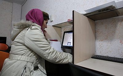 Illustrative photo of a Muslim woman wearing a head cover at an internet cafe in central Tehran. (photo credit: Vahid Salemi/AP)