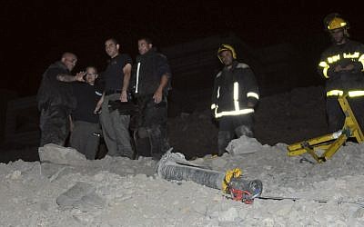 Police stand next to a rocket that landed in Eilat in early April (photo credit: AP/Yehuda Ben Itah)