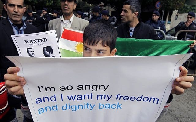 A Syrian Kurdish boy carries a banner during a protest outside the Arab League office in Beirut, Lebanon, in December 2011 (photo credit: AP/Bilal Hussein)