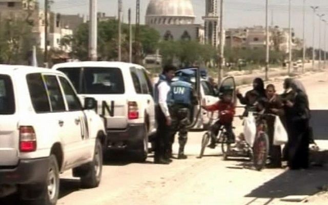 UN observers visit the city of Homs on Saturday (photo credit: Syria TV/AP video)