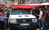 A UN vehicle drives through a crowd of Assad supporters in Homs (photo credit: AP/SANA)
