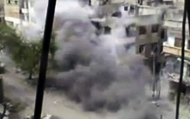 Image from amateur video purportedly showing shelling in Homs hours before the first UN observers arrive in Damascus (photo credit: AP/Shaam News Network)