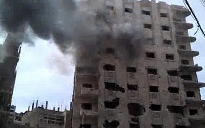 A building damaged by government shelling Saturday in Homs, Syria. (photo credit: AP/Bambuser)