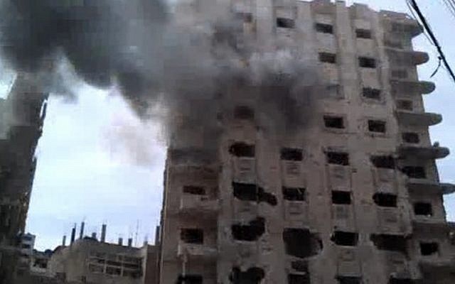 A building damaged by government shelling Saturday in Homs, Syria. (photo credit: AP/Bambuser)