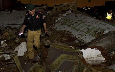 Pakistani rescue workers amid of a wreckage of the Boeing 737 passenger plane which crashed in the outskirts of Islamabad. (photo credit: AP) Pakistani rescue workers amid of a wreckage of the Boeing 737 passenger plane which crashed in the outskirts of Islamabad. (photo credit: AP)