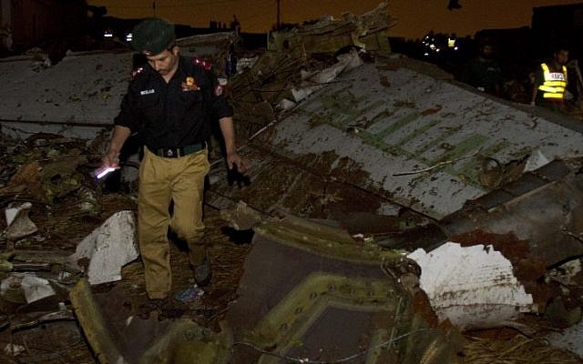 Pakistani rescue workers amid wreckage of the Boeing 737 passenger plane which crashed in the outskirts of Islamabad. (photo credit: AP) Pakistani rescue workers amid wreckage of the Boeing 737 passenger plane which crashed in the outskirts of Islamabad. (photo credit: AP)