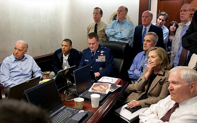 US Secretary of State Hillary Rodham Clinton, at right with hand covering mouth, President Barack Obama, second from left, Vice President Joe Biden, left, Secretary of Defense Robert Gates, right, and members of the national security team watch an update on the mission against Osama bin Laden in the White House Situation Room on May 1, 2011. The image, released by the White House, was digitally altered by the source to obscure the details of a document in front of Secretary Clinton. (photo credit: AP Photo/The White House, Pete Souza)