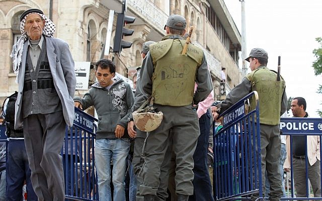 Arab men walk by border police next to Damascus gate in Jerusalem's Old City (photo credit: Nati Shohat/Flash90)