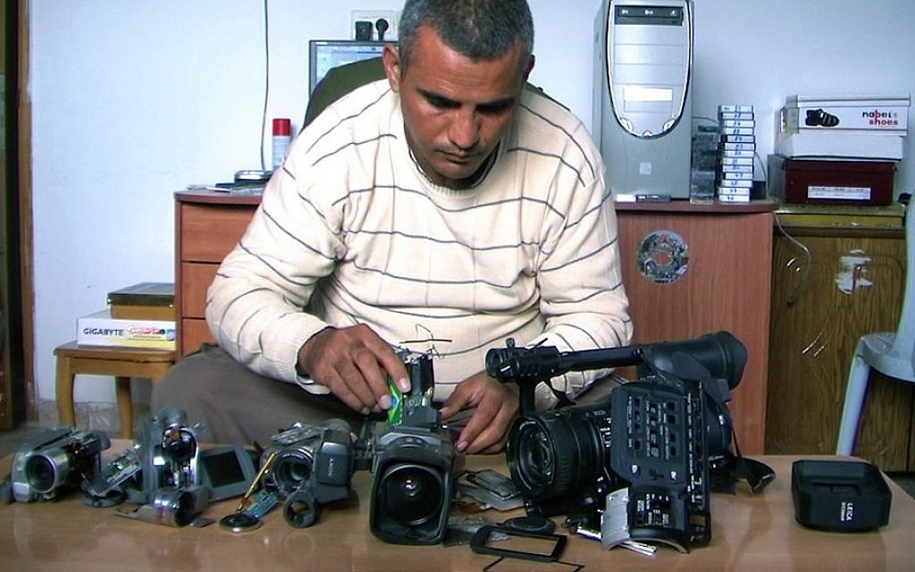 Co-director Emad Burnat with his five broken cameras. (photo credit: Kino Lorber)