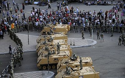 Armored Egyptian military vehicles block the road outside of the Ministry of Defense in Cairo, Friday. (photo credit: AP/Ahmed Hammad)