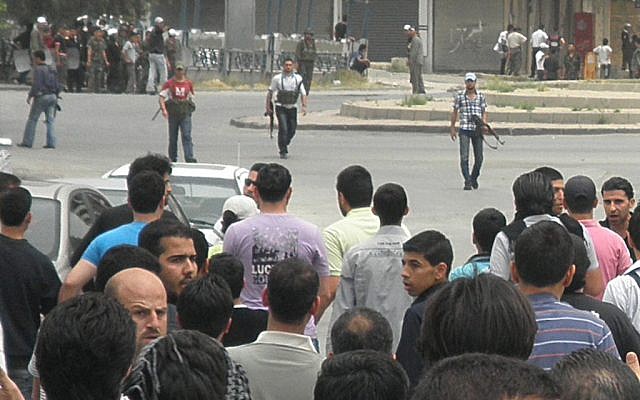 Syrian forces armed with machine guns push back protesters in Damascus on Sunday (photo credit: AP)