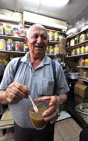 Zion Arama, of Arama cafe, with a fresh brew of white Yemeni coffee in his hand (photo credit: David Katz)