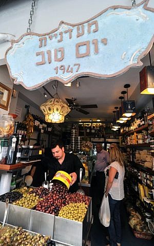 Eitan Yom Tov replenishes a quick-depleting batch of olives at the Yom Tov Delicatessen (photo credit: David Katz)