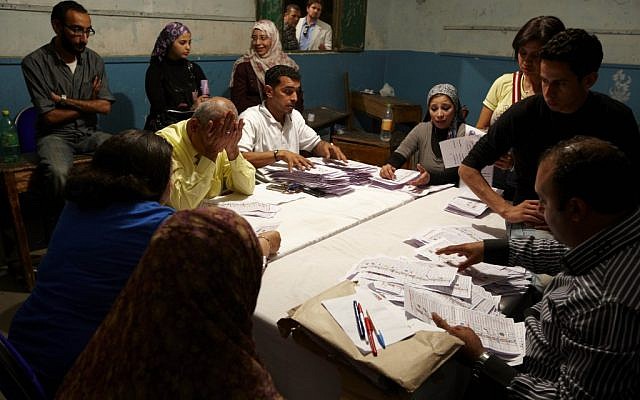 Election workers counting voted in Cairo Thursday. (photo credit: AP/Fredrik Persson)