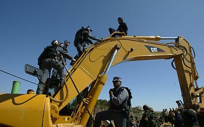 Israeli police atop a Caterpillar bulldozer during a demonstration against the security barrier. (photo credit: Ahmad Gharabli / Flash90)
