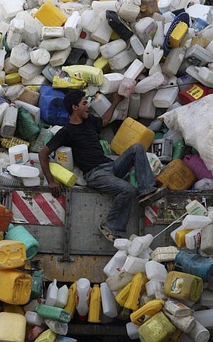 A Palestinian boy collects plastic containers in Gaza (photo credit: Wissam Nassar/Flash90)