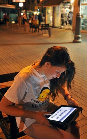 A teenager girl surfs the internet in Jerusalem. (illustrative photo credit: Serge Attal/Flash90)