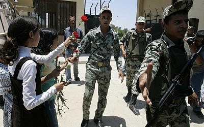 Palestinian children hand flowers to Egyptian soldiers at Rafah border crossing (photo credit:  Abed Rahim Khatib / Flash 90)