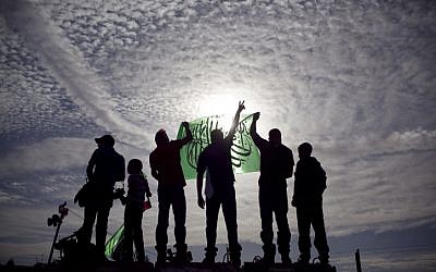 Palestinians hold up Hamas flags (photo credit: Matanya Tausig/Flash90)