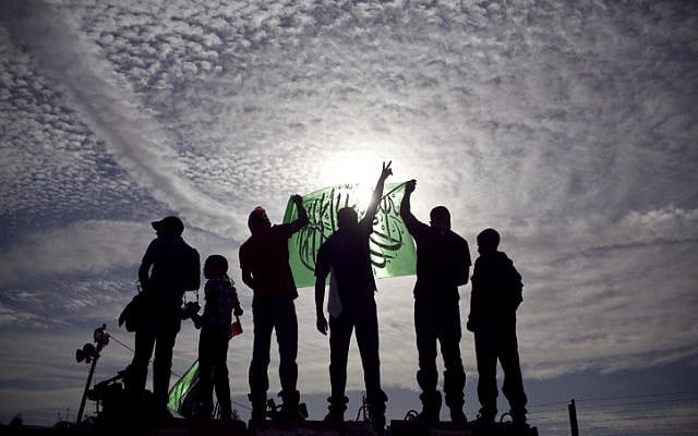 Palestinians hold up Hamas flags (photo credit: Matanya Tausig/Flash90)