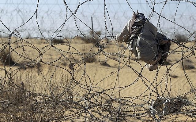 A coat left behind on the Israeli-Egyptian border fence after a migrant crossed illegally from Egypt into Israel (photo credit: Tsafrir Abayov/Flash9)