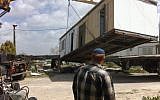 A Jewish settler watches as a mobile home is moved from the illegal outpost of Ramat Gilad in March. (photo credit: Roy Sharon/Flash90)
